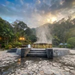 Steam rising from Raksa Warin Hot Springs in a forested setting in Ranong